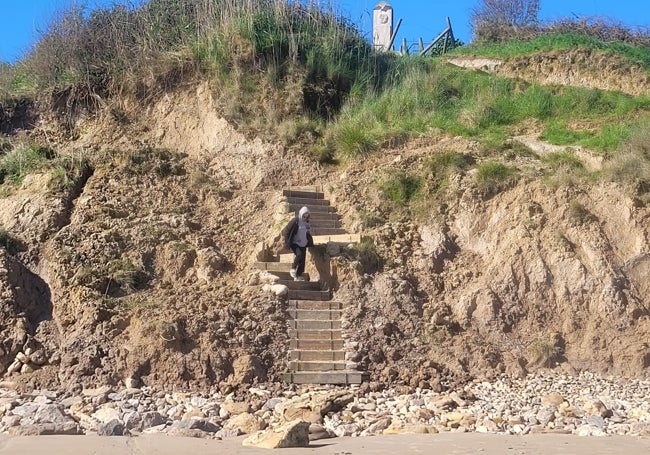 Una mujer baja por las escaleras de acceso al monumento.