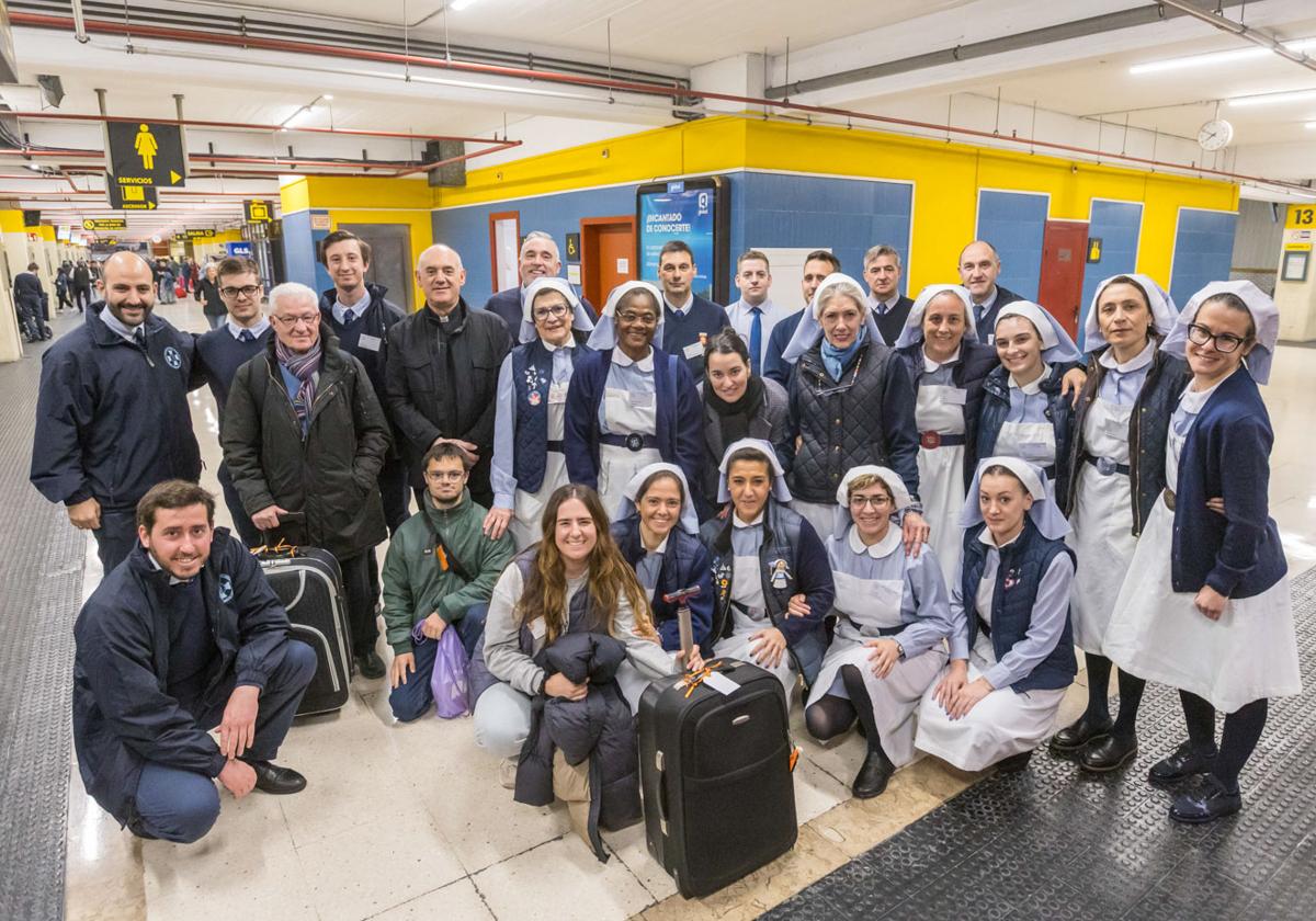 Foto de familia de voluntarios junto al obispo de Santander, Arturo Pablo Ros, antes de subir a los autobuses que han salido hoy desde Santander.
