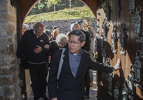 En Santo Toribio. Luis Antonio Tagle cruza la Puerta del Perdón en 2017. Detrás, el párroco de Suances, Baldomero Maza, ayuda a la madre del cardenal filipino.