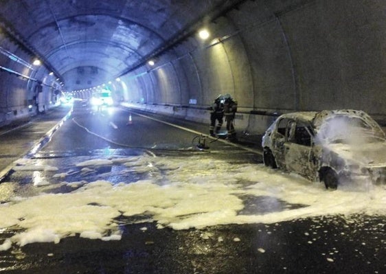 Imagen de esta tarde de los bomberos y el coche que se ha incendiado en el túnel de la autovía.