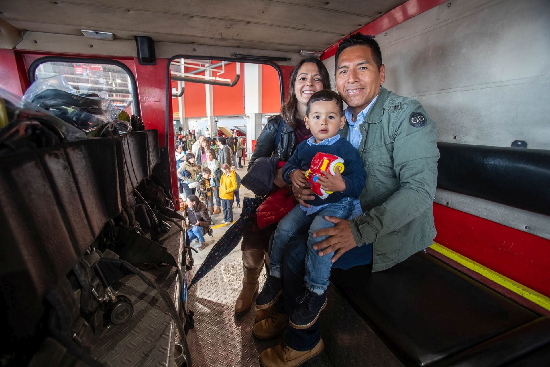 Una familia, este domingo, posa dentro de uno de los vehículos que utilizan los bomberos de la capital cántabra en sus salidas. 
