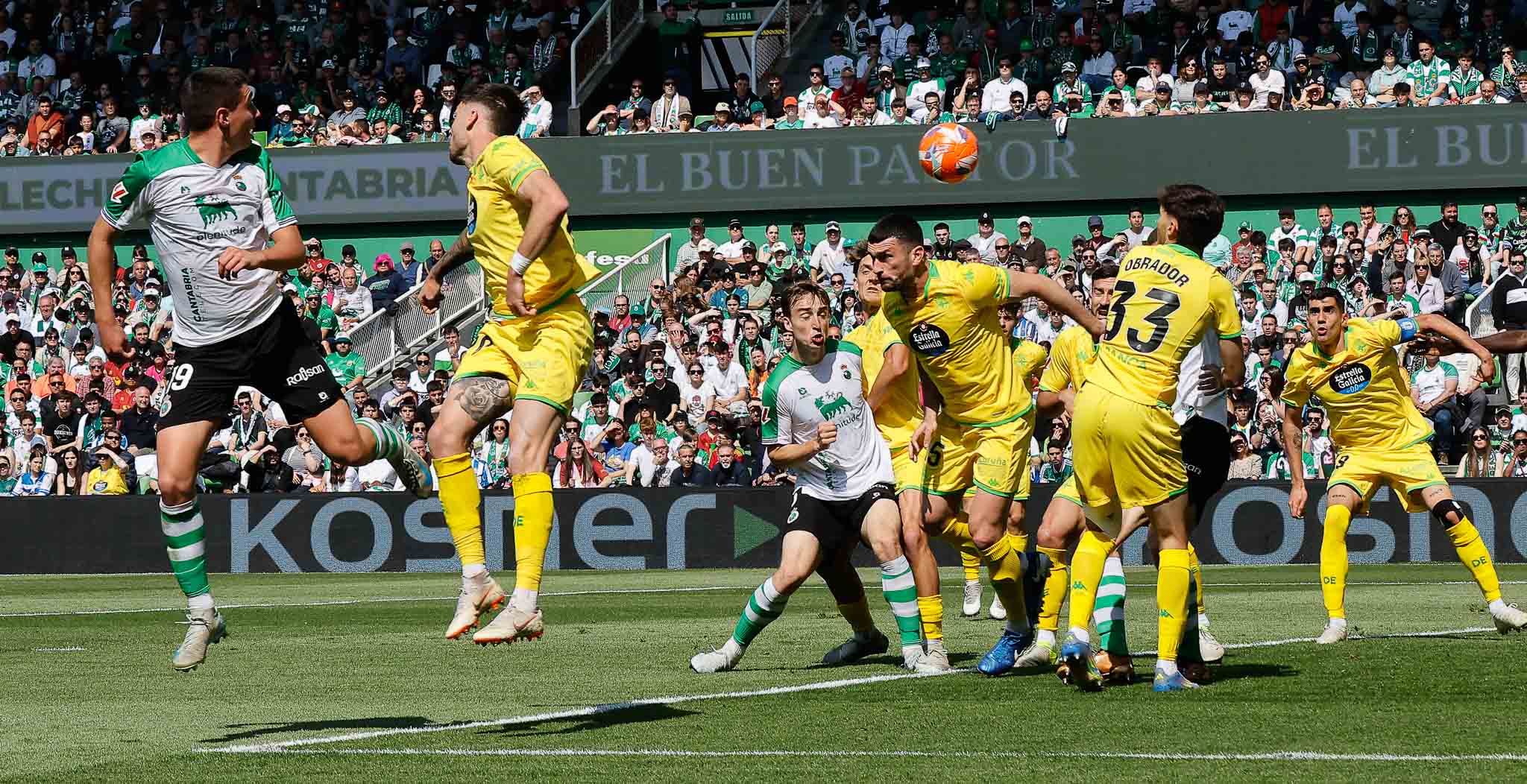 Javi Castro se prepara para rematar y un jugador del Dépor trata de obstaculizarle