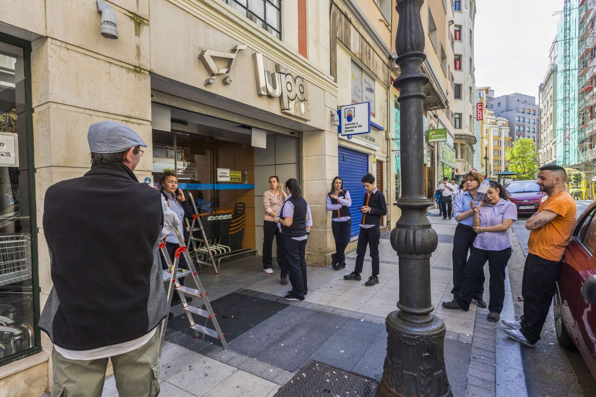 Los trabajadores de un Lupa en la calle Rualasal, Santander, esperan a las puertas del supermercado al no poder trabajar por el corte total de suministro.