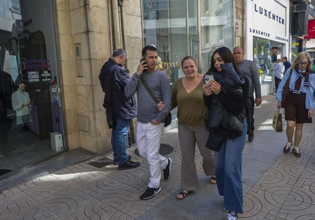 Vecinos intentan informarse y comunicarse con sus móviles, tras el apagón.