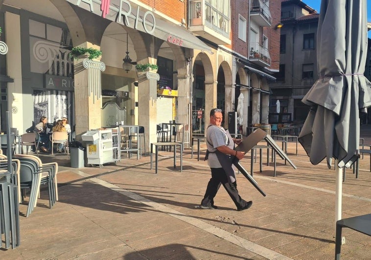 José, de la cafetería Atrio, coloca las mesas de su terraza en la plaza Baldomero Iglesias, para recobrar la normalidad tras el apagón de ayer.