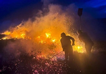 Dos bomberos trabajan para sofocar un incendio en Sel de la Carrera.