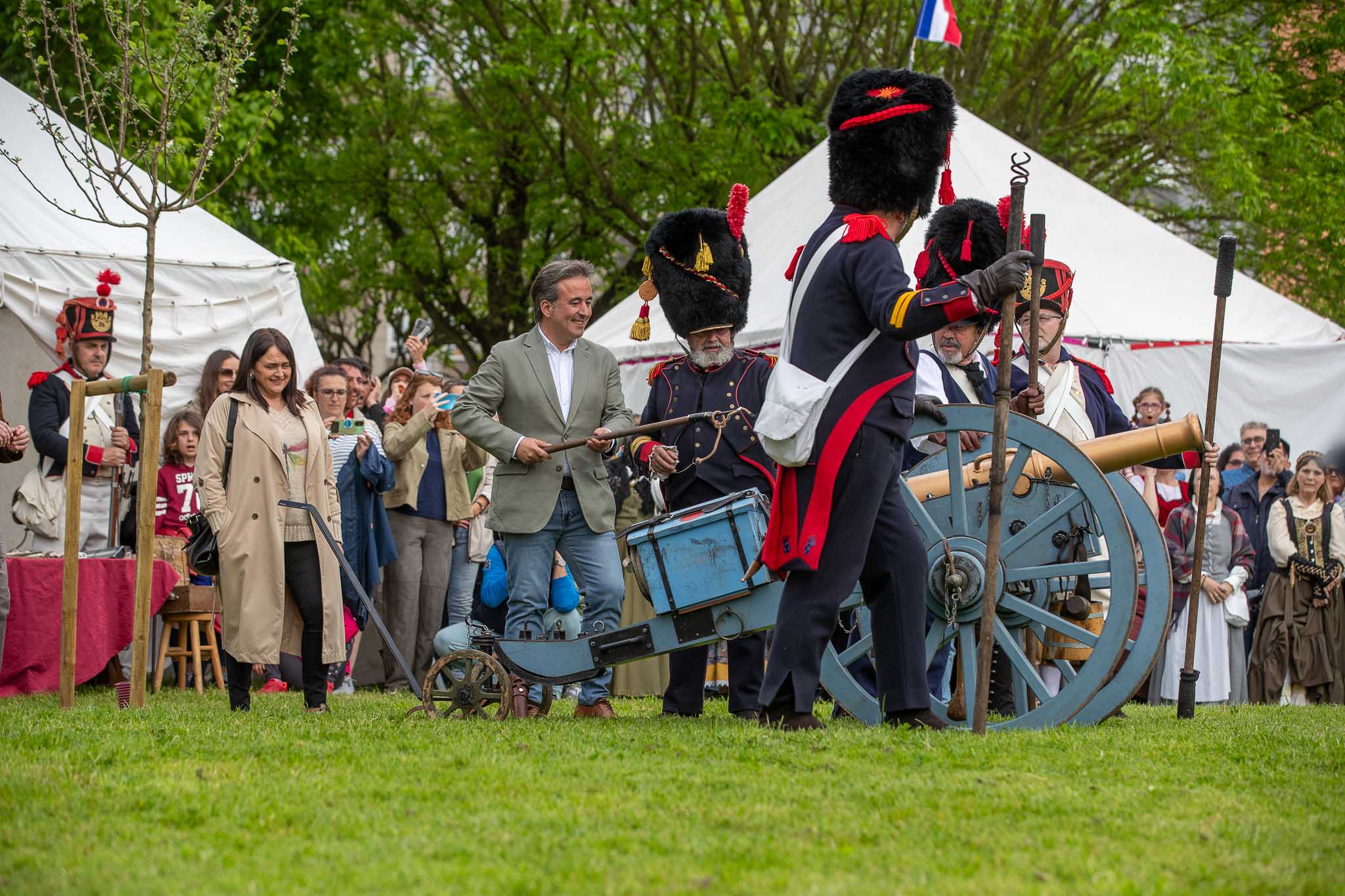 Movellán se dispone a disparar el cañón durante la ceremonia, junto a figurantes y responsables municipales. 