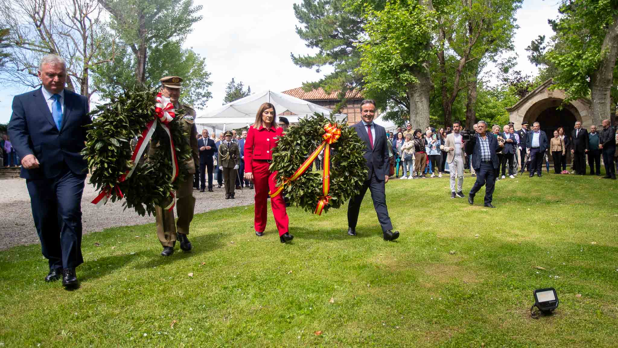 El descendiente de Pedro Velarde, María José Sáenz de Buruaga y el alcalde, Diego Movellán, se dirigen al monolito del homenajeado a realizar la ofrenda floral.