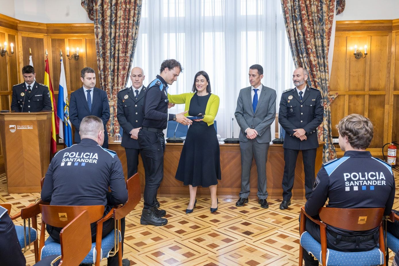Uno de los nuevos agentes, en el acto de bienvenida, recibe su placa en manos de Gema Igual. 