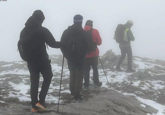 Los jóvenes guiados entre la niebla por uno de los rescatadores del Greim de la Guardia Civil.