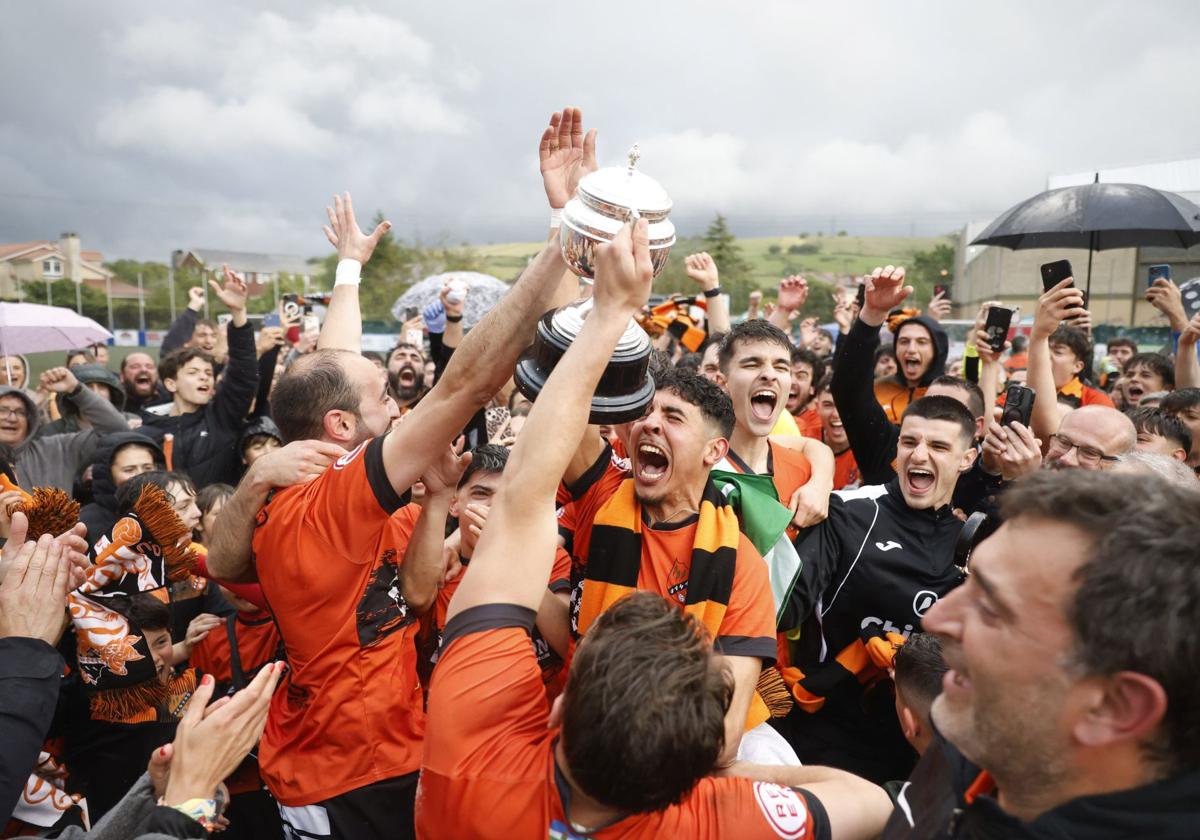 Los jugadores del Sámano celebran el ascenso con sus aficionados sobre el mismo campo.