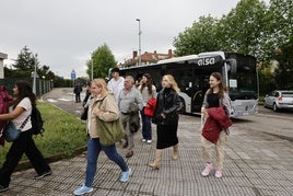 Un grupo de viajeros se baja de un autobús en la estación de El Astillero para coger un tren con destino a Santander.