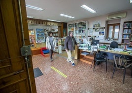 Asun Arabaolaza, con la vicepresidenta de la asociación de vecinos, Virginia Pérez, recogiendo la biblioteca tras su cierre.