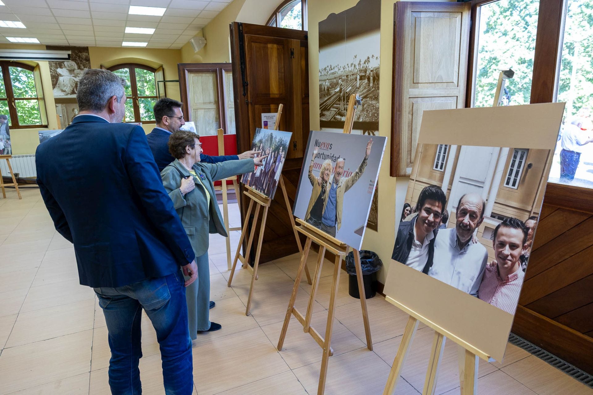 Los asistentes observan una pequeña exposición de fotos de Alfredo Pérez Rubalcaba.