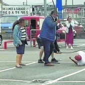 El procesado, tendido en el suelo y apaleado por tres hombres.
