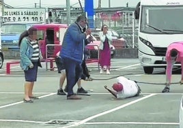 El procesado, tendido en el suelo y apaleado por tres hombres.