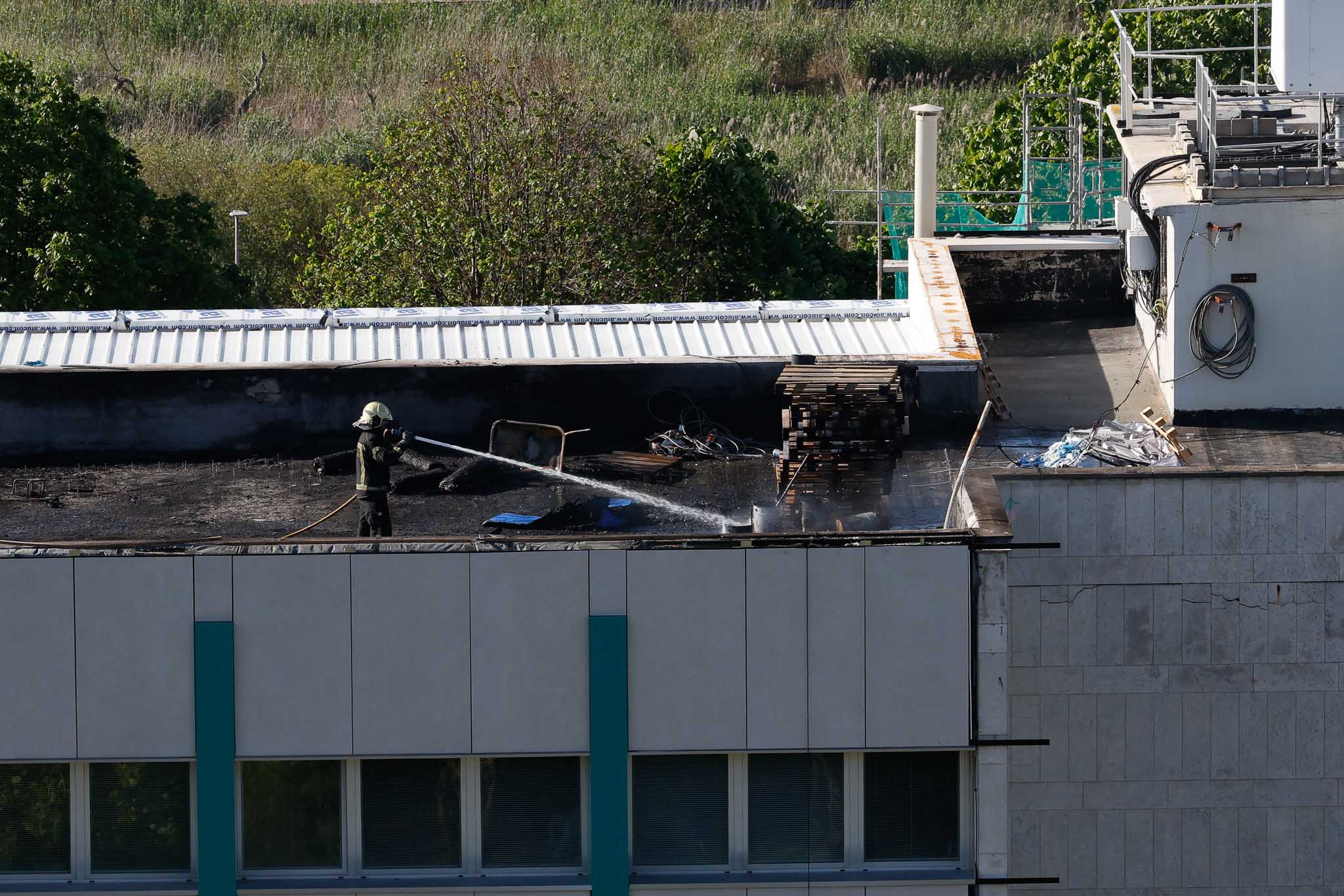 Uno de los bomberos refrescando la zona en la que se generó la columna de humo.