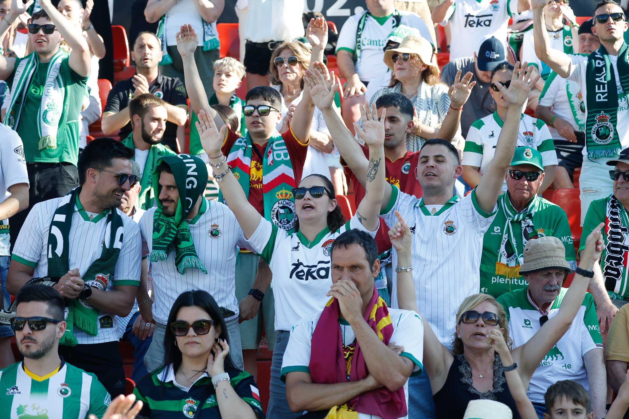 Los aficionados animan al equipo con los brazos en alto