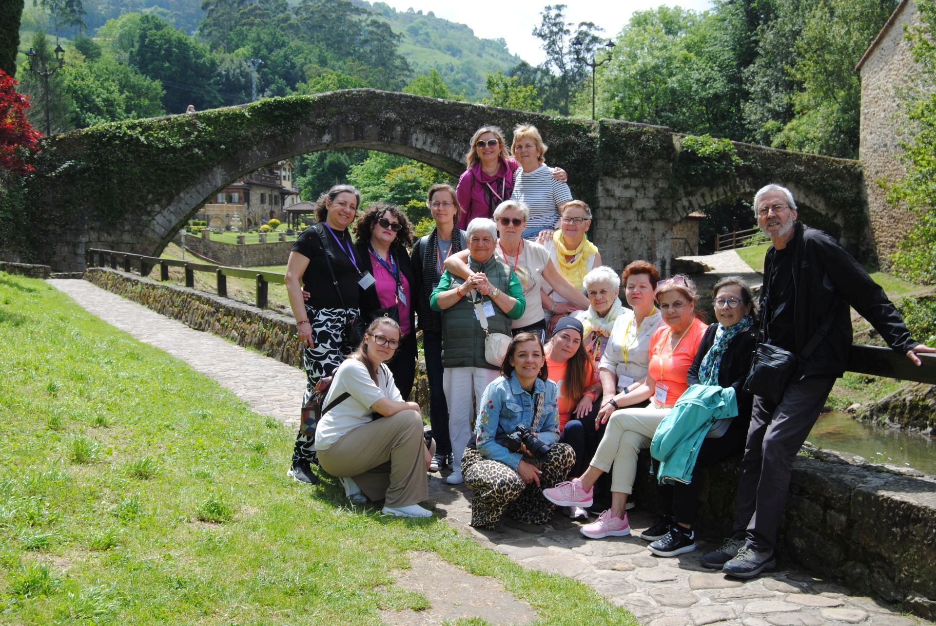 Miembros de la asociación de mayores, con la delegación polaca, ante el emblemático puente romano de Liérganes.