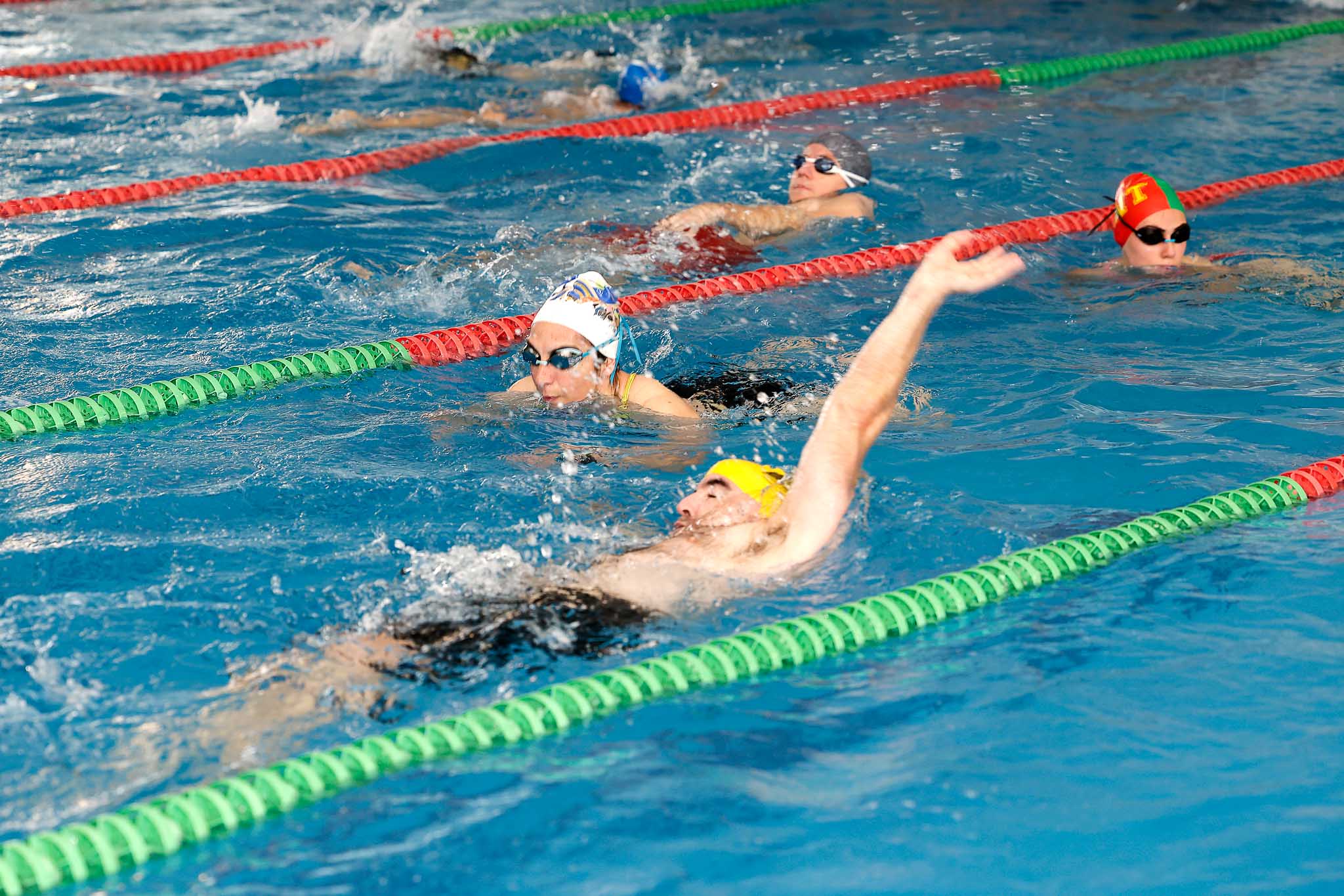 Varios nadadores en las calles de la piscina municipal de La Lechera.