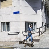 Una mujer camina junto a la nueva placa de la calle Alto de los Leoneses, que ahora se llama Benito Madariaga.