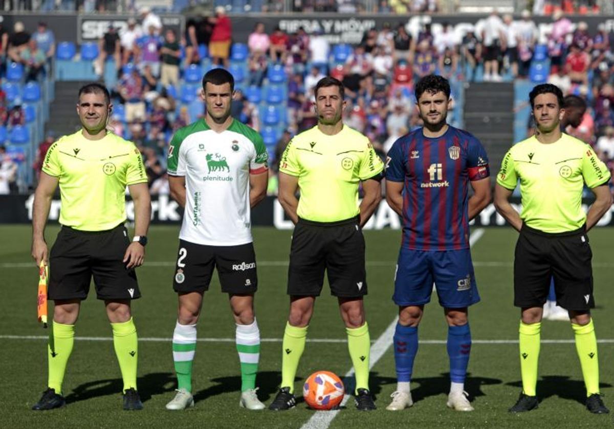 Álvaro Mantilla, con el brazalete de capitán, posa junto a Sergio Ortuño y el equipo arbitral en el Nuevo Pepico Amat.