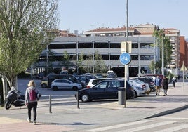 Vecinos caminan frente al aparcamiento en altura de La Carmencita, en Torrelavega.