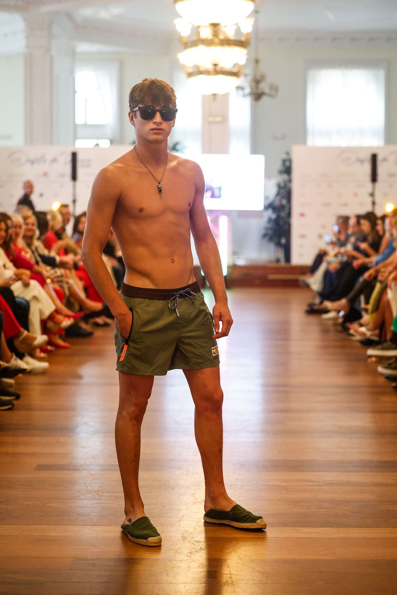 El joven Antón Vuelta con traje de baño de Sandra Alonso, gafas de Minor y alpargatas de Luimar.