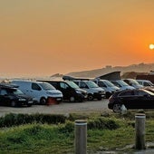 Varios coches estacionados en el aparcamiento de la playa de Oyambre.