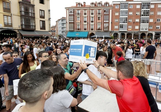 Concejales entregan un lote de camisetas a un peñista, el año pasado, en la plaza Baldomero Iglesias.