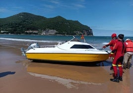 Una barca a punto de volcar con un ocupante encalla en la playa de Laredo