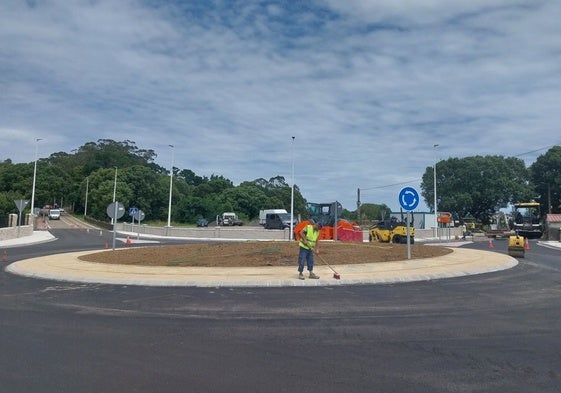 Un operario da los últimos retoques a la glorieta mientras se asfalta el vial.