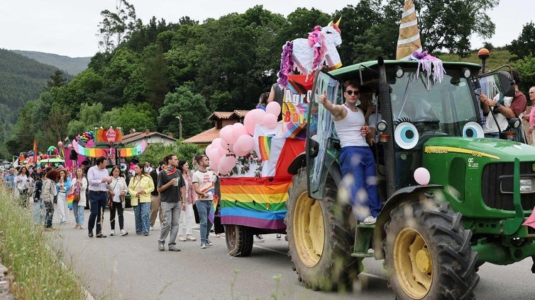 Uno de los tractores decorados como carrozas con una estela de público detrás.