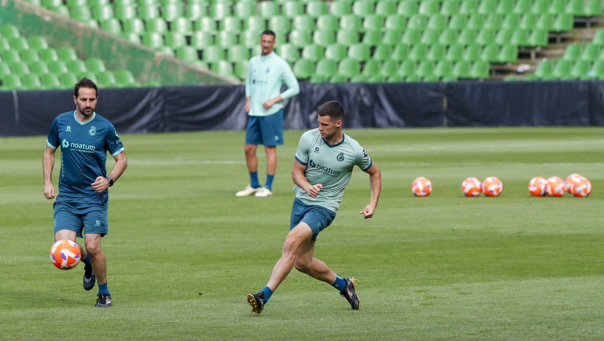 Mantilla pasa el balón junto al segundo entrenador, Pablo Álvarez.
