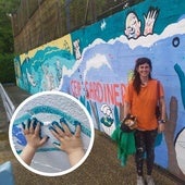 La artista Paula Vallar posa junto al mural en el colegio de El Sardinero.