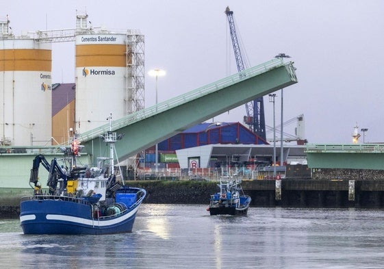 Dos embarcaciones pesqueras pasan bajo el puente levadizo de Raos, averiado desde el pasado diciembre.