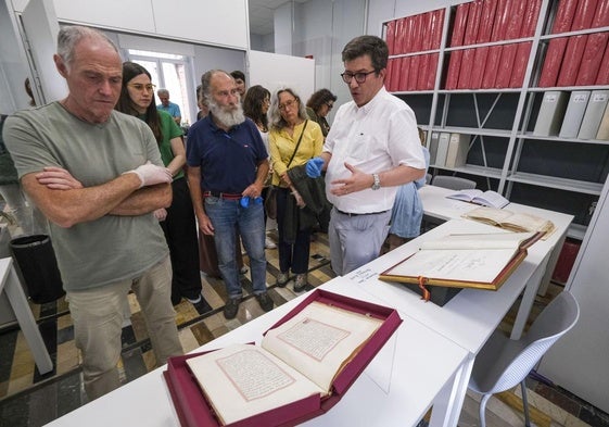 El técnico Álvaro del Castillo (derecha) muestra el libro que contiene la concesión a Santander del Título de Ciudad en 1755.