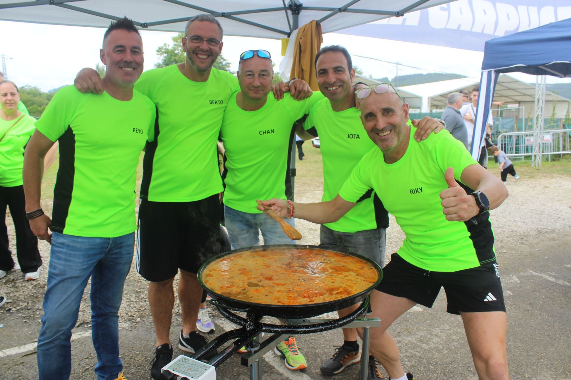 La peña Otra Ronda preparando la paella y posando para la cámara.