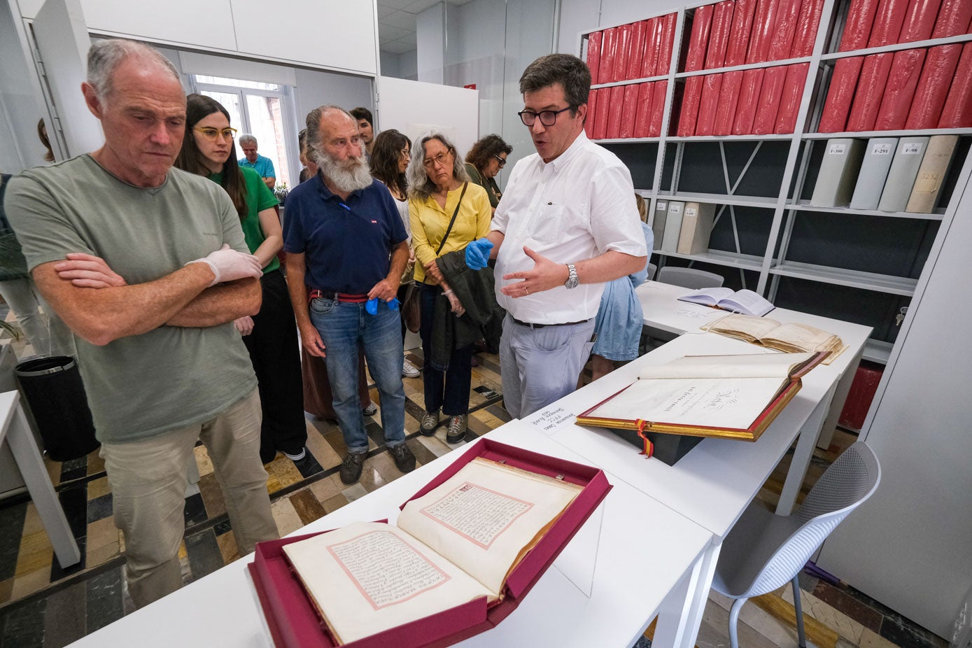 Álvaro del Castillo (a la derecha, de blanco) exhibe el Título de Ciudad durante una de las visitas de esta semana al Archivo Municipal de Santander.