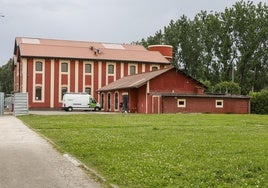 Edificio de la antigua sidrería, en primer término, con las instalaciones del Centro de Investigación del Medio Ambiente (CIMA) al fondo.