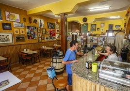 Basi Díaz sirve y charla con un cliente del establecimiento, ayer, en el bar de la Peña Bolística de Torrelavega.
