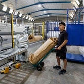 Un trabajador transporta una mercancía en una nave.