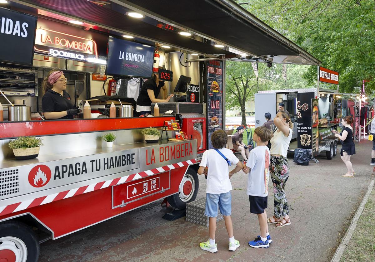 Clientes se interesan ayer por la carta en una de las doce 'foodtrucks' aparcadas en el parque Manuel Barquín de Torrelavega.