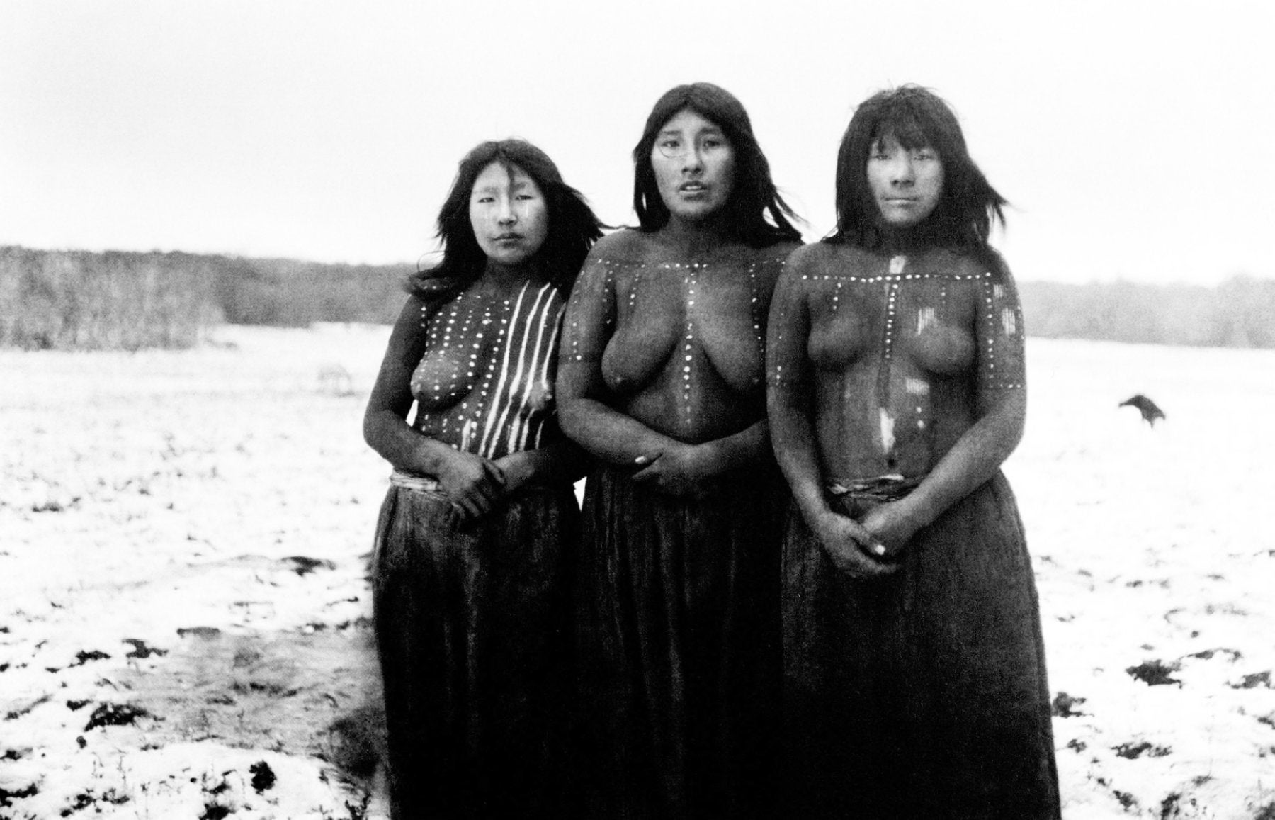 Elek, Angela Loij e Imshuta durante una danza llamada Kewánix en honor a Tanu. Cada mujer tiene el cuerpo pintado con arcilla roja y motivos blancos específicos de su linaje. Selknam, 1919-1924.