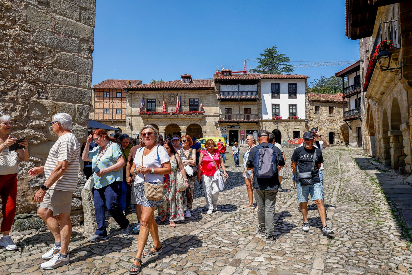 Un grupo de turistas deja atrás la Plaza Mayor de la villa.