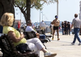 Cántabros y visitantes disfrutan del buen tiempo en el paseo marítimo de Santander.