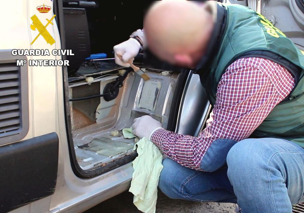 Un miembro de la Agrupación de Tráfico investiga el número de bastidor de un vehículo.