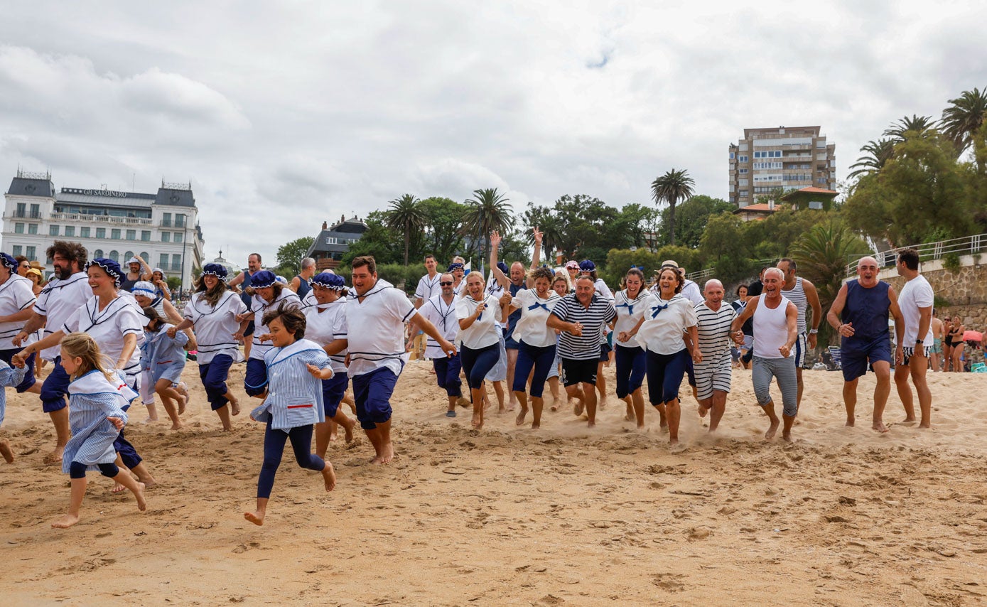 Los participantes corren a zambullirse en el agua, este domingo, a las cinco de la tarde.