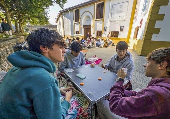 Amigos jugando a las cartas mientras hacían cola a las puertas de la plaza de toros de Santander.