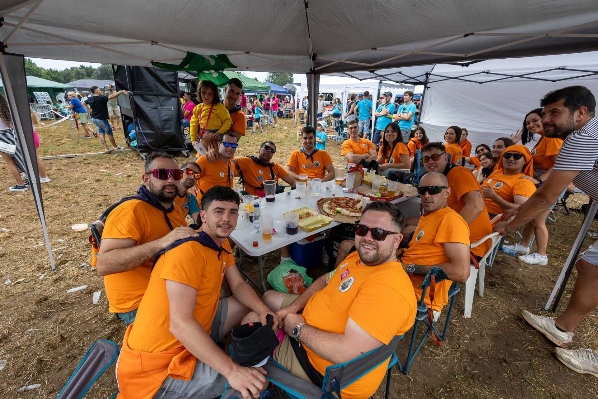 La peña de los Embriagados, vestidos con camisetas naranjas, este domingo, minutos antes de comenzar el campeonato de peñas en Revilla de Camargo. 
